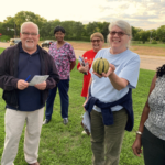 group of folks showing the vegetable they picked